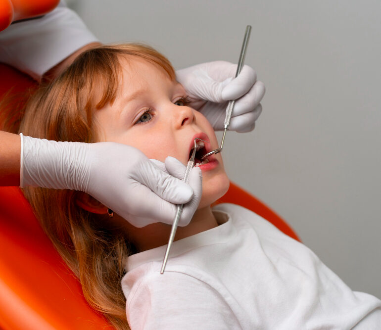 Bambina con la bocca aperta durante un controllo di odontoiatria pediatrica