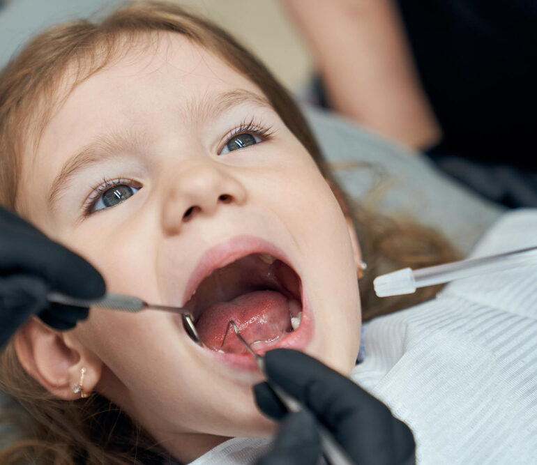 Bambina piccola durante una visita dal dentista per bambini